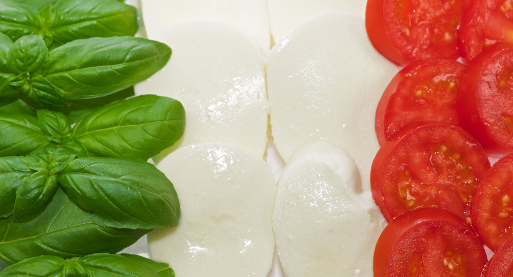 bazylia ser mozzarella i pomidory ułożone w kolorach flagi włoskiej